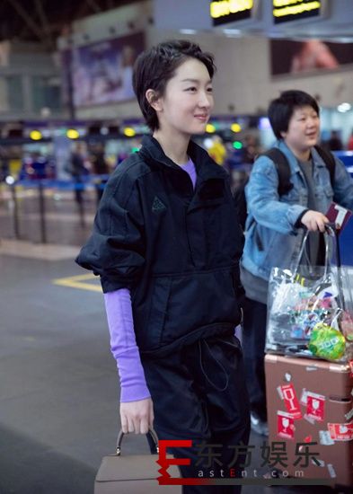 周冬雨黑色工装现身机场 紫色内搭明亮个性引人关注